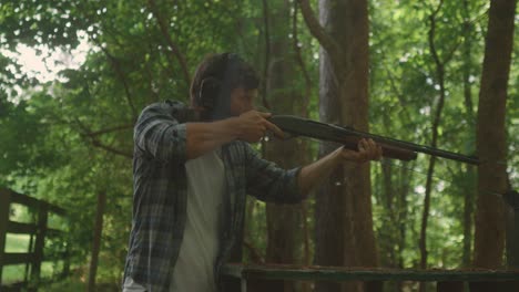 sesión de entrenamiento de disparos en el bosque, cámara lenta de hombre caucásico con orejeras
