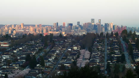 city of vancouver canada surrounded with green trees and different buildings during sunrise.