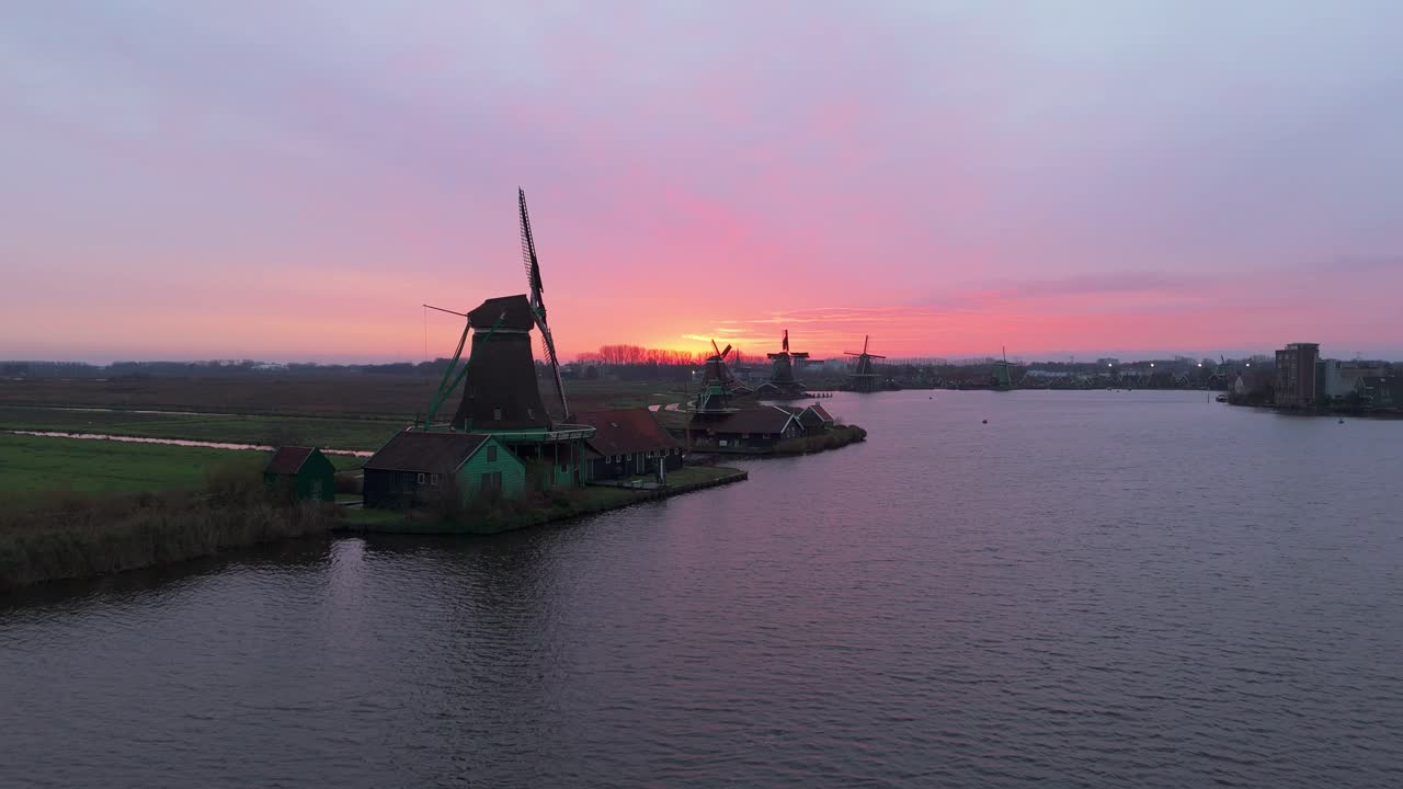 Dronevideo of the Windmills of zaanse schans (close to Amsterdam) in the early dawn lights.