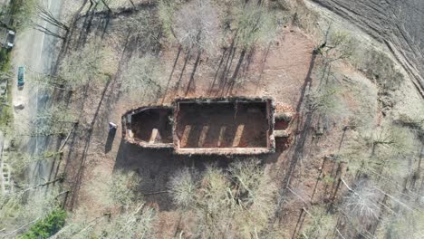 aerial top down ascend over destroyed church remains, wall outline shape