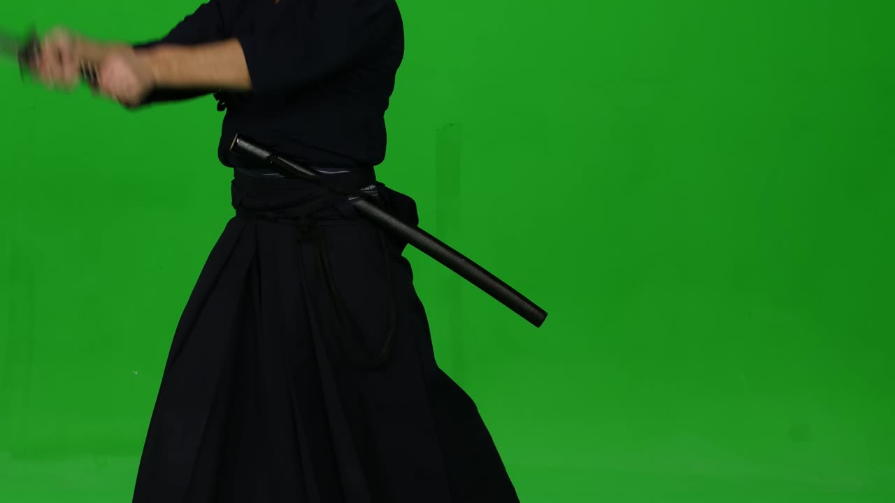 guerrero de kendo masculino practicando arte marcial con el bokken de bambú en la pantalla verde. cerca