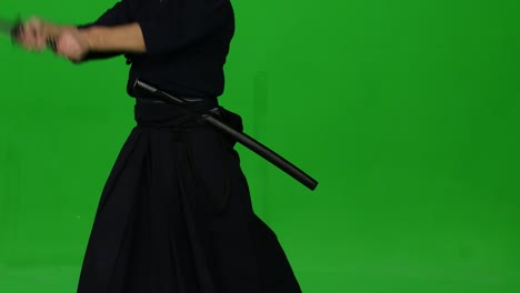 masculine kendo warrior practicing martial art with the bamboo bokken on green screen. close up