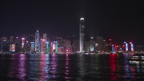 victoria harbour by night, hong kong, china. beautiful high dynamic range professional footage. central skyscrapers in the background a the star ferry passing by.