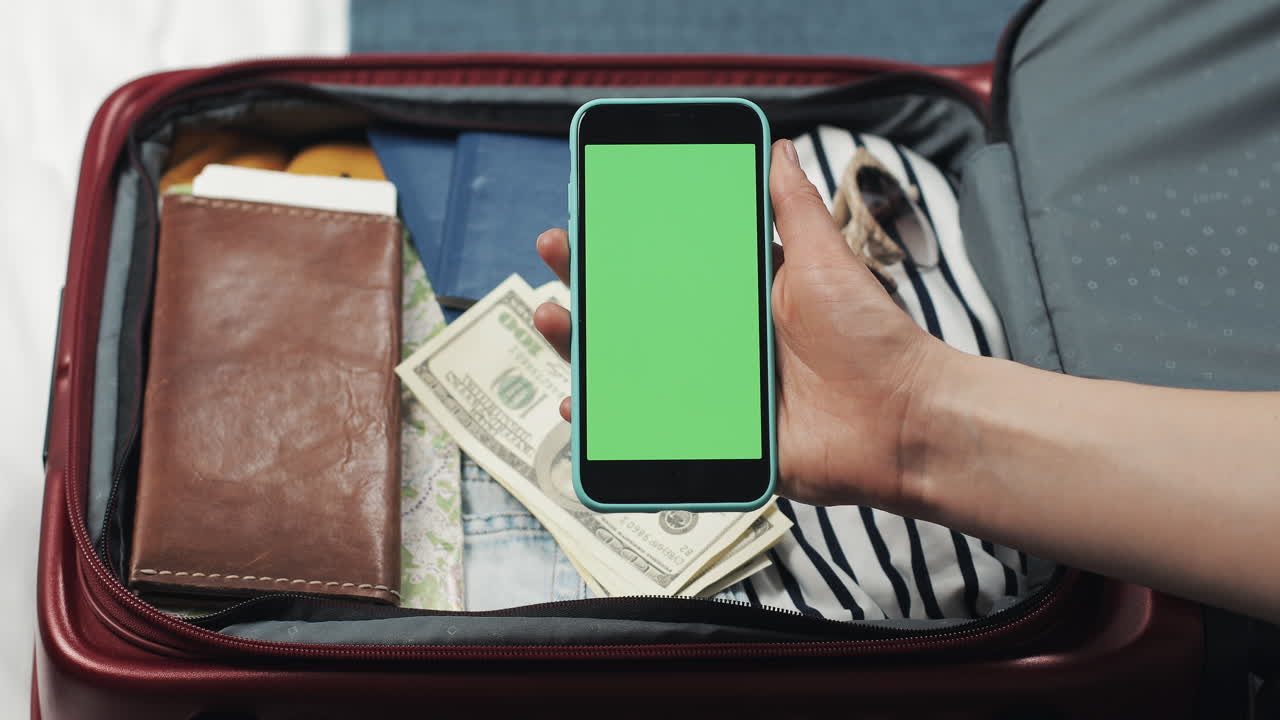 Packing a suitcase for travel with phone and money