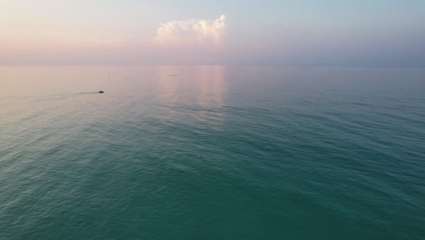 Vista-Aérea-Panorámica-De-Un-Kayak-En-El-Golfo-De-México-Al-Amanecer-En-La-Playa-De-Pensacola-Florida-Con-Nubes-Esponjosas-Al-Amanecer