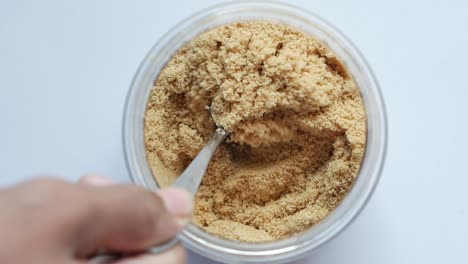azúcar marrón en un frasco con cuchara