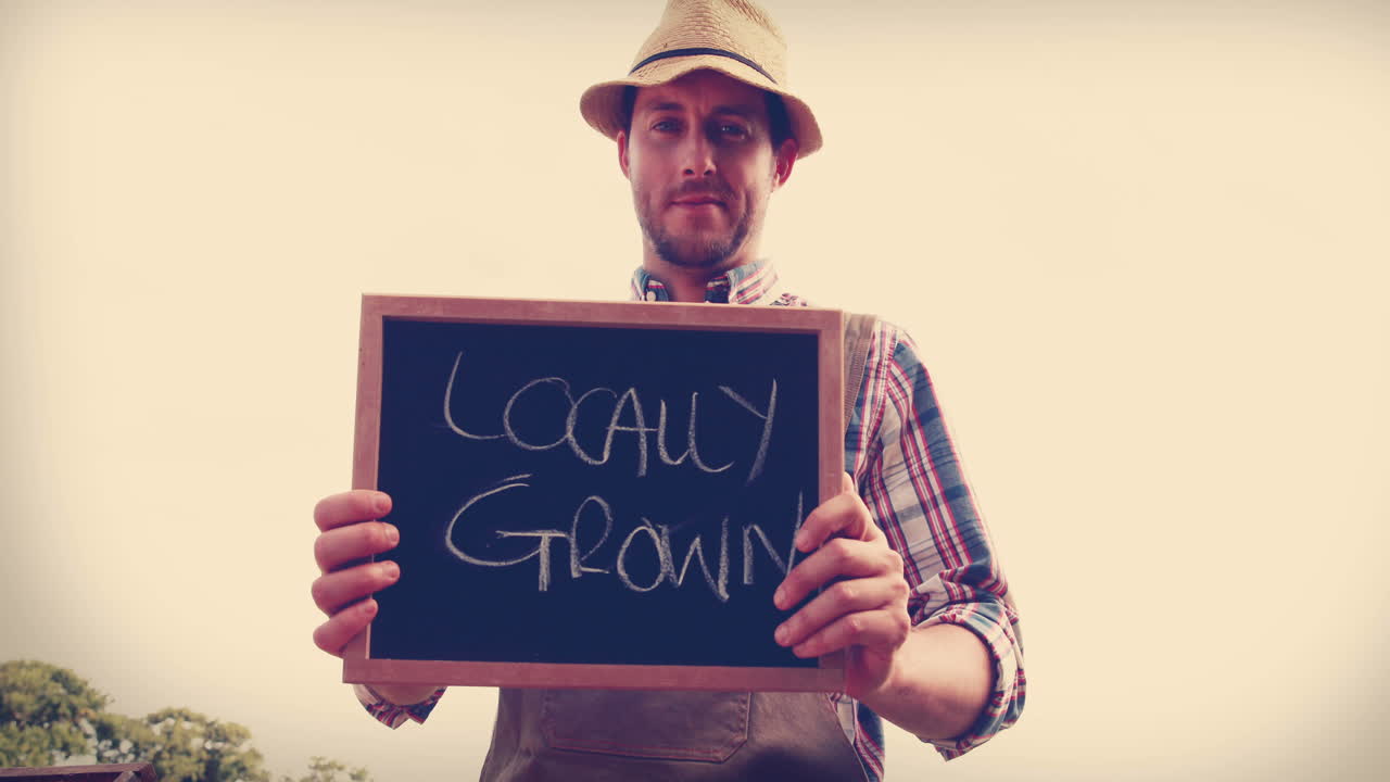 un granjero feliz mostrando la pizarra