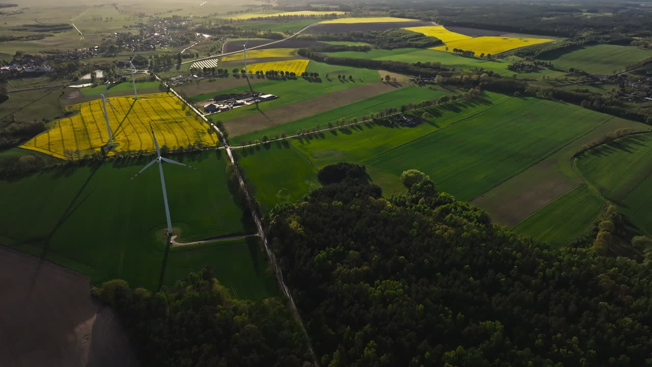 Pull out drone shot of wind turbines in a wind farm during the day, renewable energy