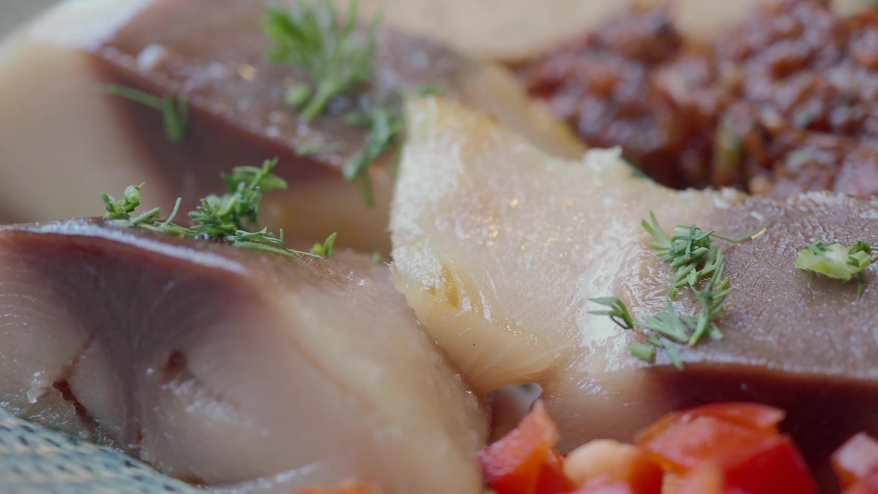 Nærbillede af tilberedte fiskefileter pyntet med krydderurter og grøntsager