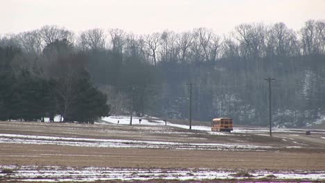 A-Bright-Yellow-School-Bus-Stops-To-Pick-Children-Up-Along-A-Rural-Road