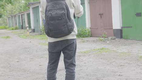 back view of a young man with backpack standing in gliwice, southern poland