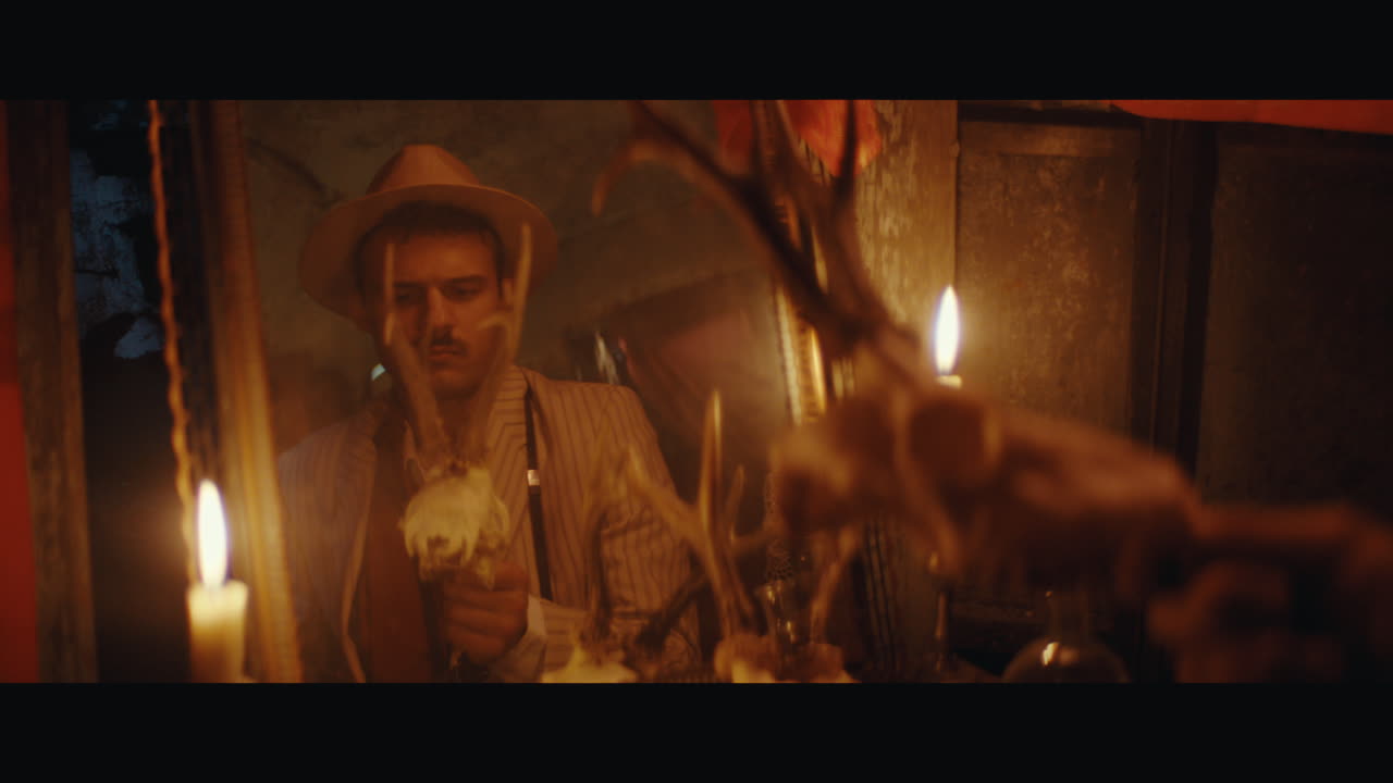 A man in hat looks into mirror in the gypsy circus cart