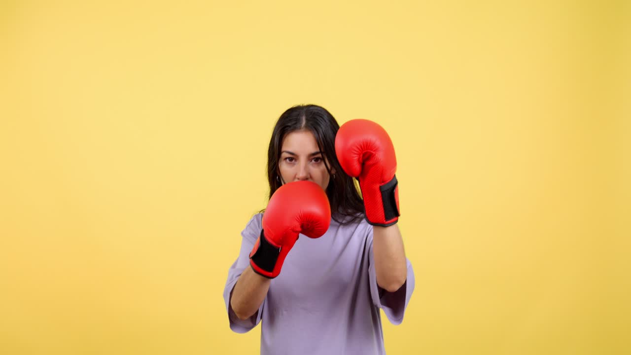 Woman in Red Boxing Gloves Training on Yellow Background