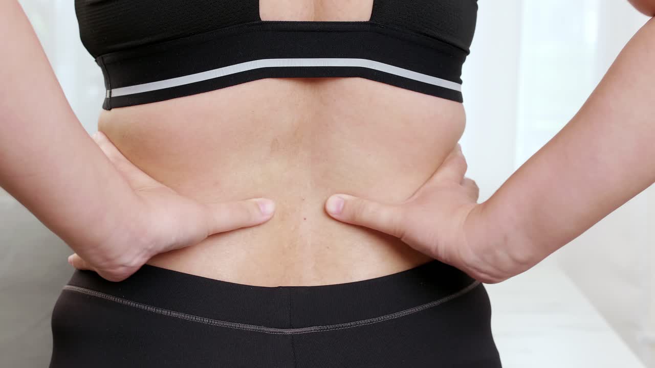 mujeres que sufren de dolor de espalda y masajean los músculos doloridos y se automasajean con la mano