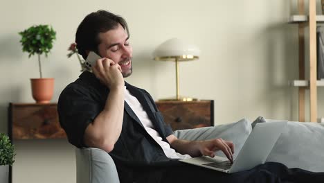 hombre independiente hablando por teléfono móvil trabajando usando portátil