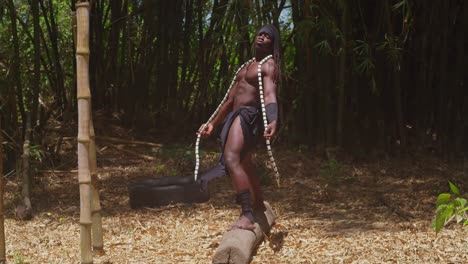 a muscular man with dark skin, dressed in a tarzan cosplay costume, stands amidst a lush forest.