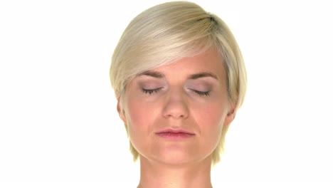 woman with a calm facial expression closing her eyes on a white studio background