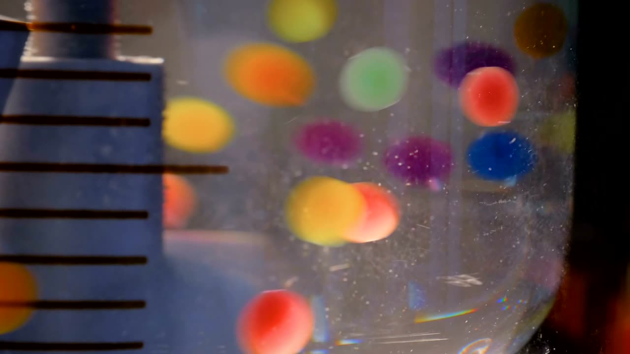 moviendo pastillas coloridas, pastillas, drogas, medicamentos en el agua en la exposición farmacéutica