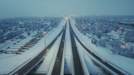 drone shot of freeway or highway traffic during rush hour on a foggy and winter evening, shot straight down the freeway as cars pass along