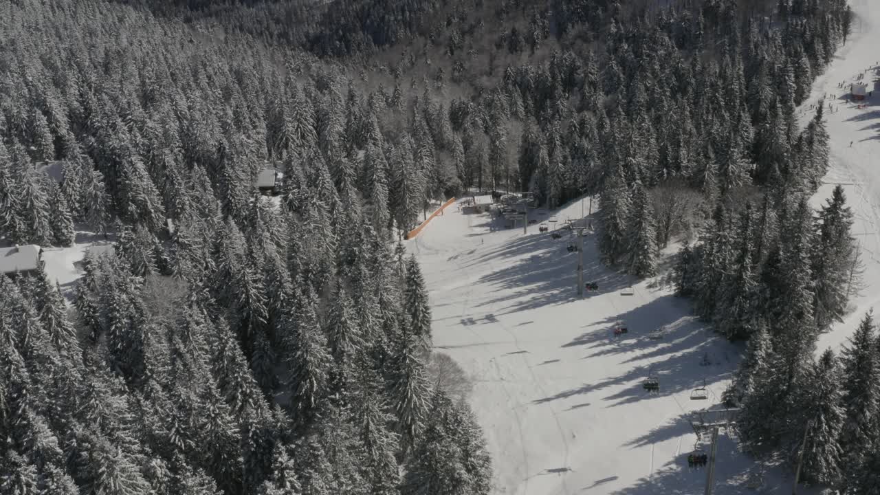 Vista in discesa con impianto di risalita sulla pista Ribnica nel resort invernale Kope in Slovenia, riprese aeree con carrello in avanti