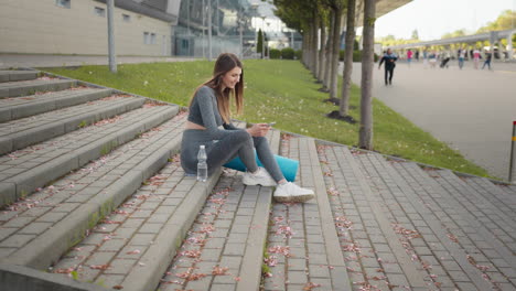 mujer relajándose en las escaleras después del entrenamiento
