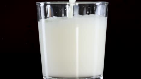 a sequence showing milk being poured into a glass, filling it gradually.