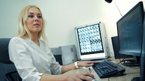 médico trabajando en una computadora en un consultorio médico