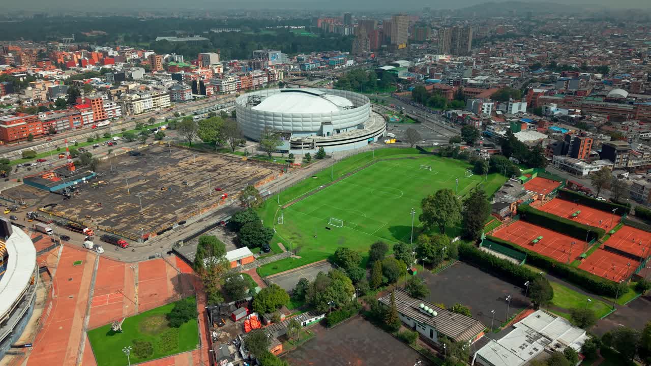 Aerial view dolly in establishing of the Movistar Arena in Bogota, Colombia on a sunny day in the residential neighborhood of Teusaquillo.
