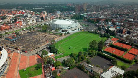 aerial view dolly in establishing of the movistar arena in bogota, colombia on a sunny day in the residential neighborhood of teusaquillo.