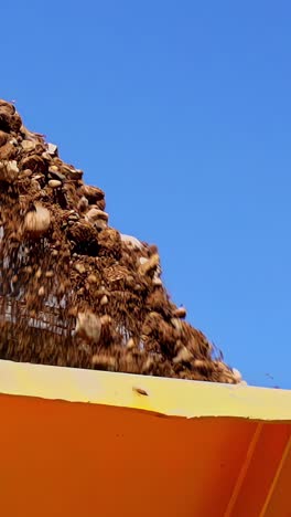 Large Iron Excavator Bucket Collects And Pours Sand Rubble And Stones In A Quarry - Vertical, Close Up