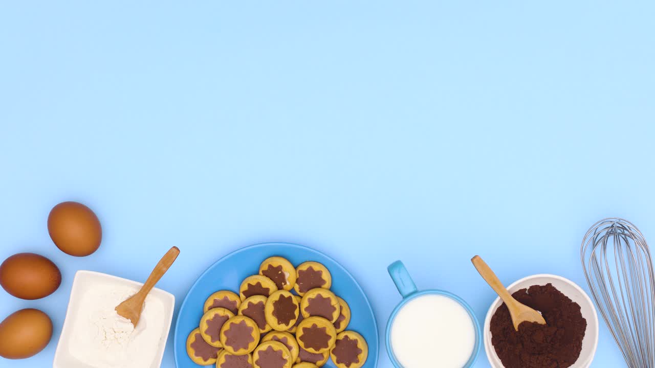 ingredientes para hornear y galletas en el plato azul se mueven en la parte inferior del tema azul. detener el movimiento