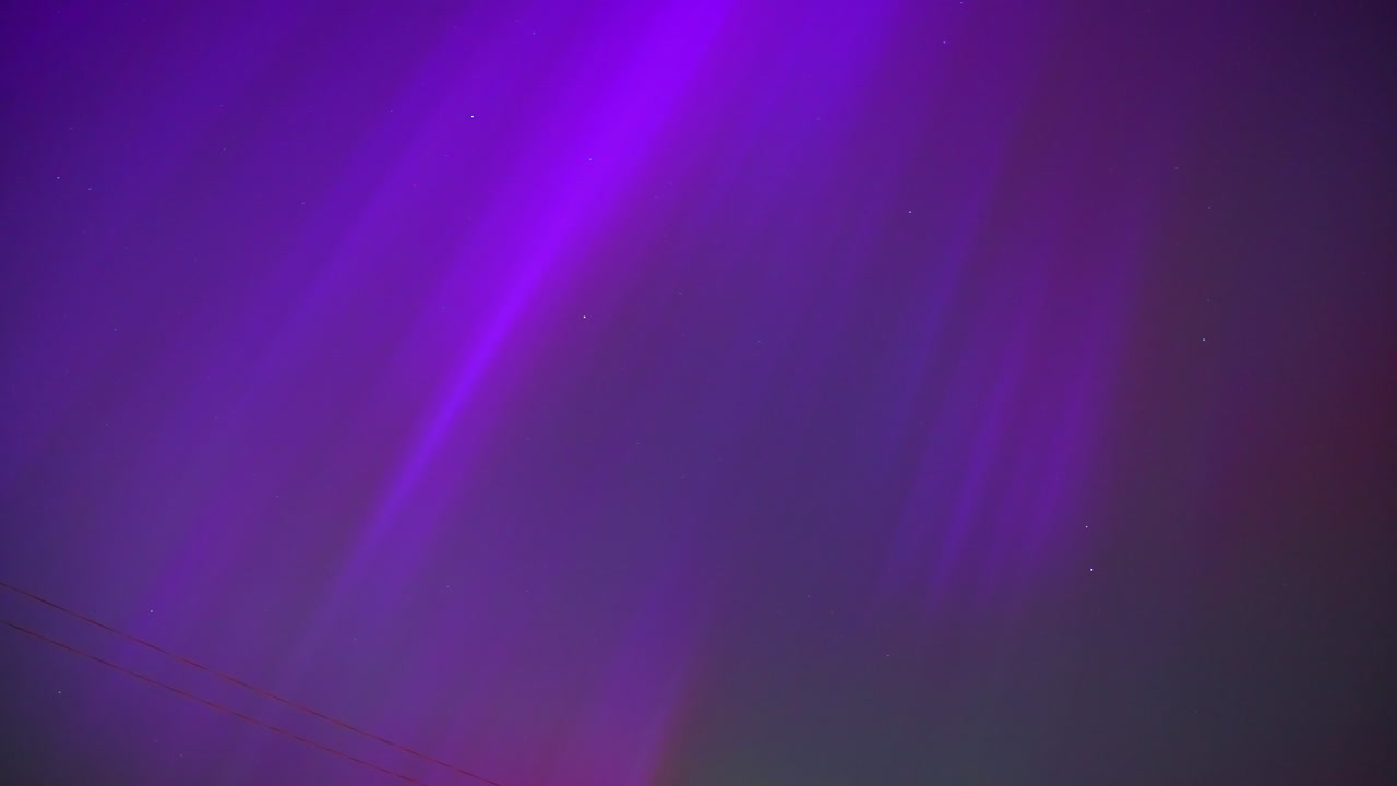 el lapso de tiempo de las luces del norte con cielo púrpura y azul