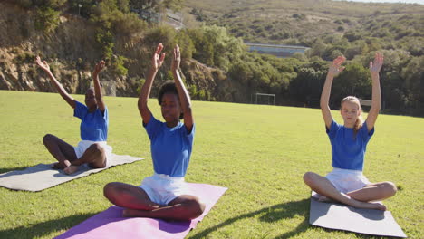 practicing yoga on mats, girls in school uniforms meditating outdoors