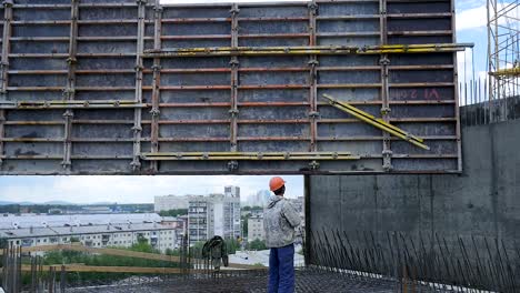 crane lifting precast concrete wall panel at a construction site
