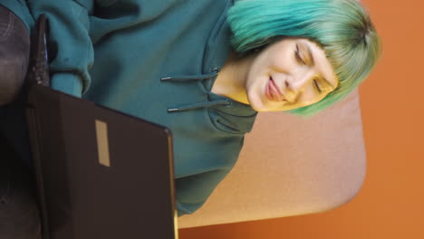 vertical video of young woman looking at laptop is happy and dancing.