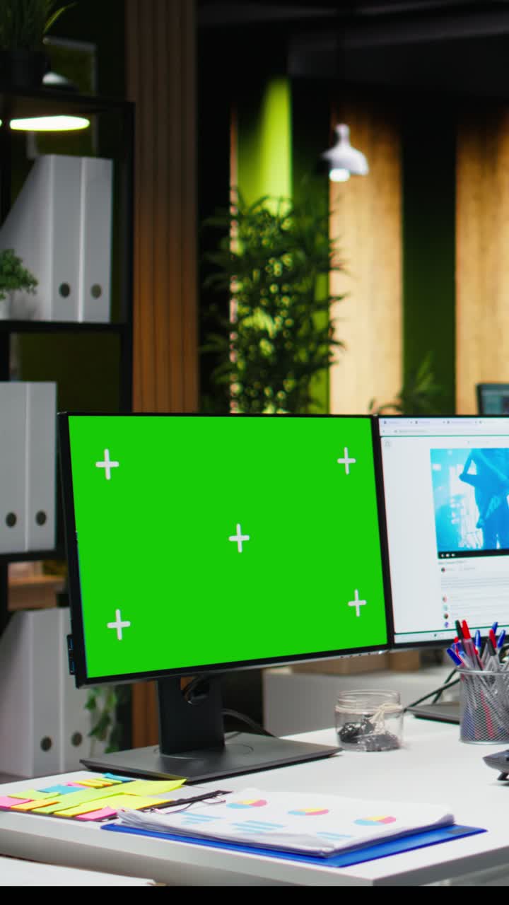 Vertical Video Green screen next to social media manager checks web platforms for content
