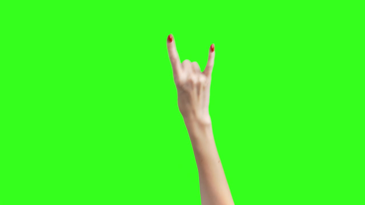 disparo de manos femeninas que muestran el gesto de la cabra en fondo verde