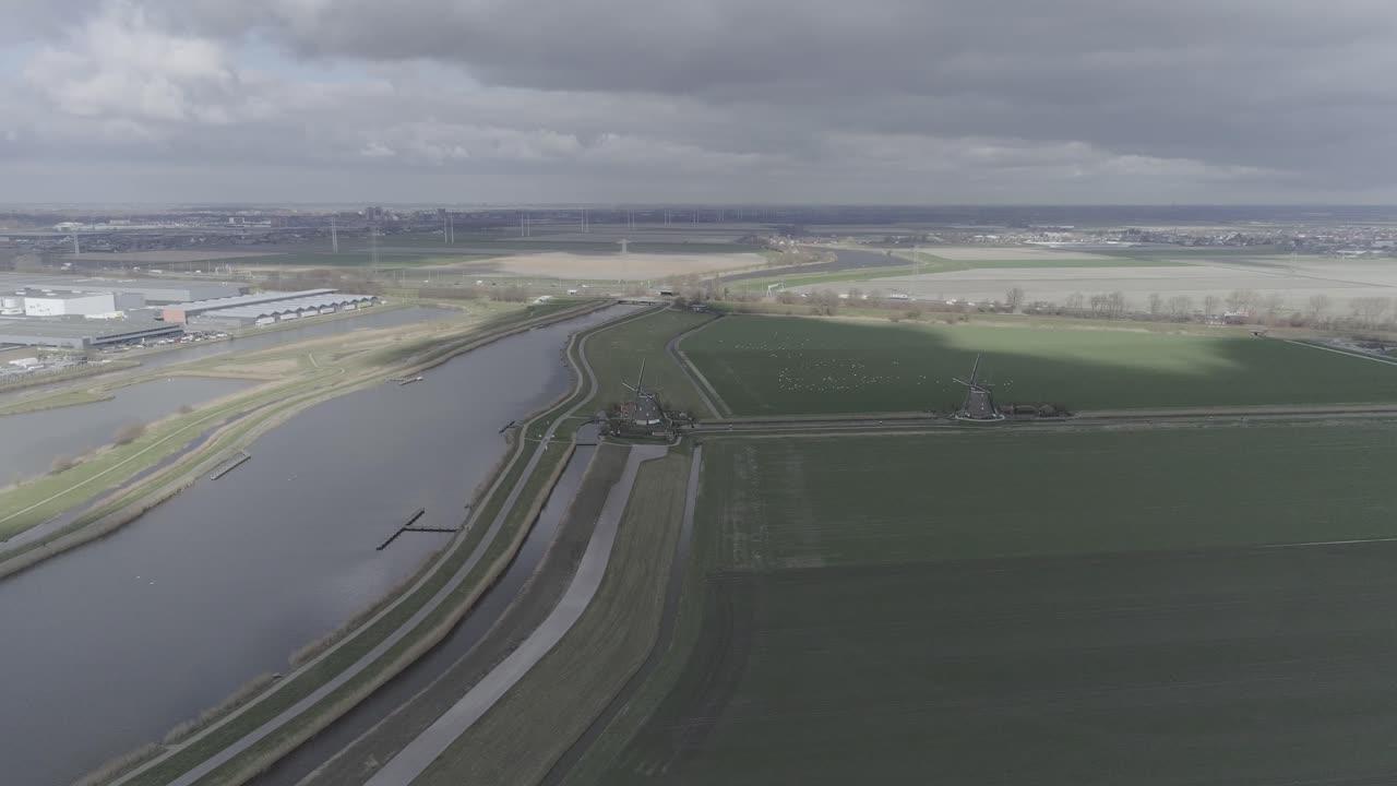 평평한 농지, 강, 풍차가 있는 전형적인 네덜란드 풍경의 드론 샷