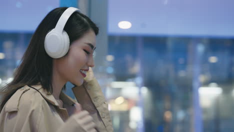 woman listening to music in a shopping mall at night