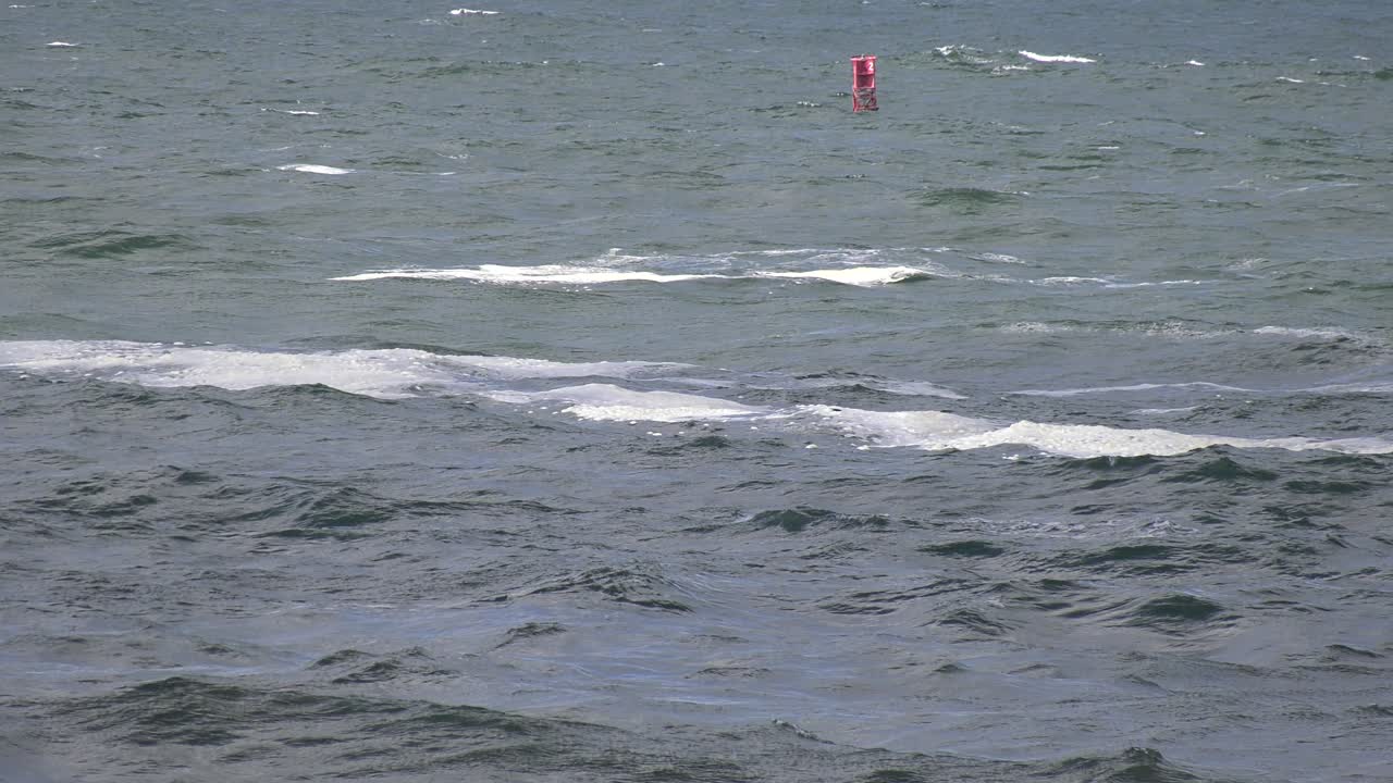 waves crash against buoy in water