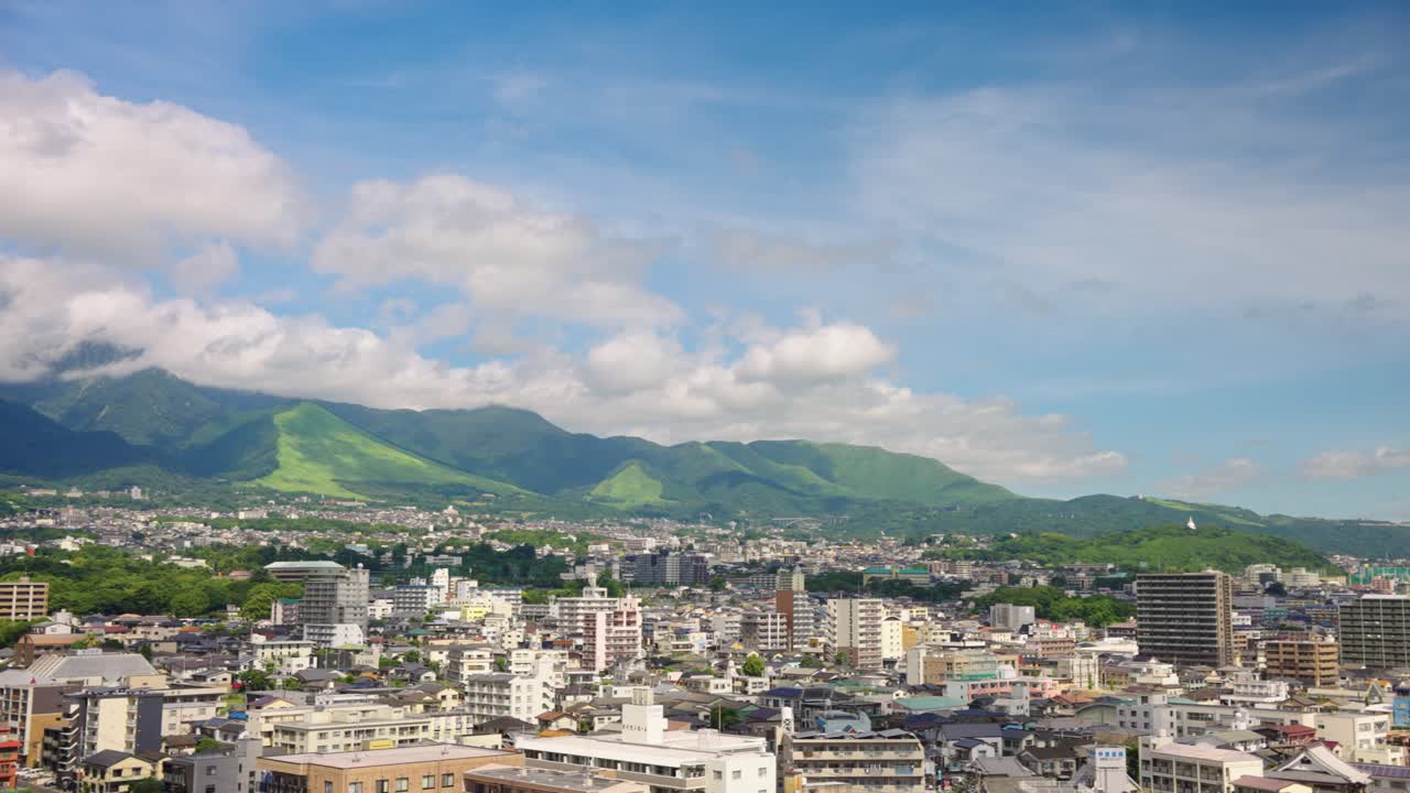 Cityscape with Mountains and Cloudy Sky