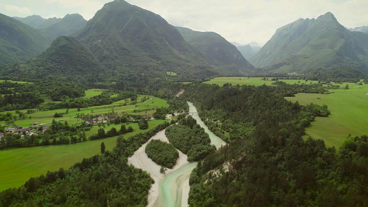 vista aérea de un pequeño pueblo con casas típicas junto al río soca, eslovenia.