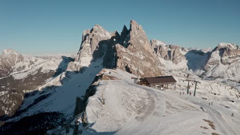 Establishing-drone-shot-over-Seceda-ski-slope-towards-iconic-mountain-ridge