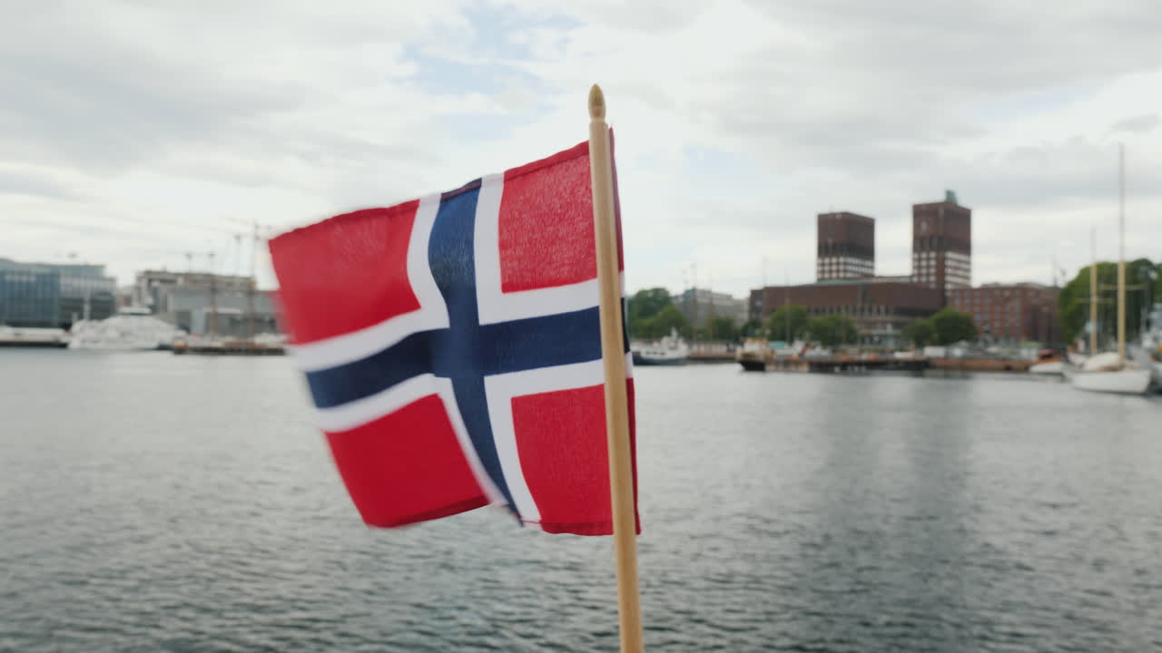 오슬로 스테디캠 샷의 도시 라인을 배경으로 노르웨이 국기와 함께 걷기