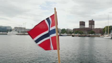 walking with the flag of norway against the background of the city line of oslo steadicam shot