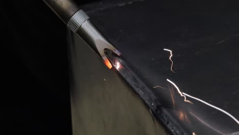 Laser-welding-machine-with-hand-hold-gun.-Laser-welding-is-shown-in-close-up.