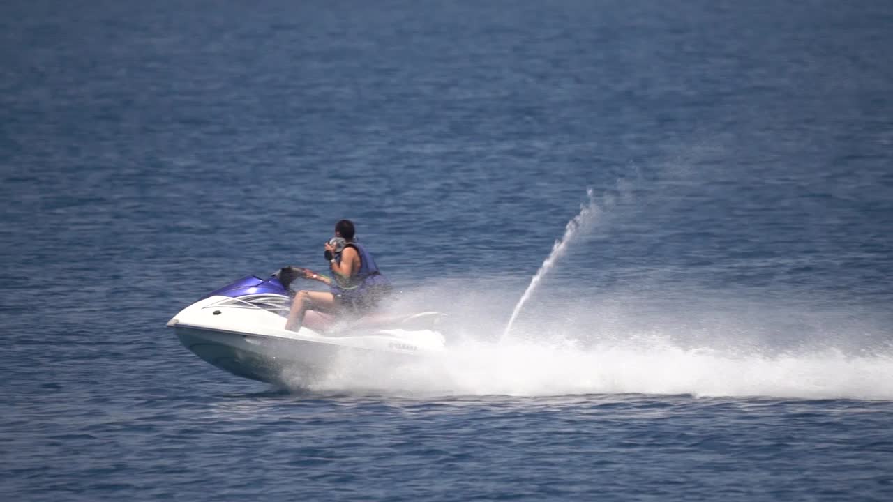 hombre montando jetski en el mar mediterráneo saltando sobre el agua en una toma de acción a cámara lenta