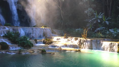 cascada kuang si cae con niebla matutina y rayos de sol brillan en luang prabang, laos