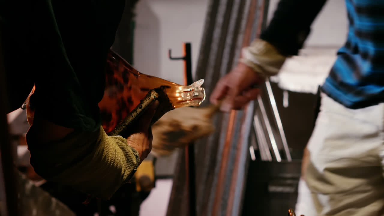 equipo de sopladores de vidrio dando forma a un vidrio fundido