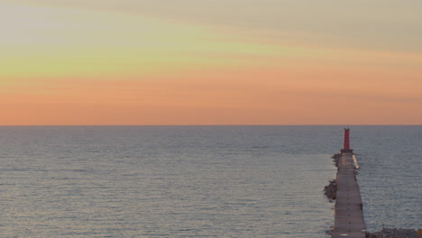 stunning aerial view of a serene lake michigan sunrise with an ombre sky and the sheboygan lighthouse with calm water, peaceful morning light, and vibrant colors. perfect for travel and nature themes.